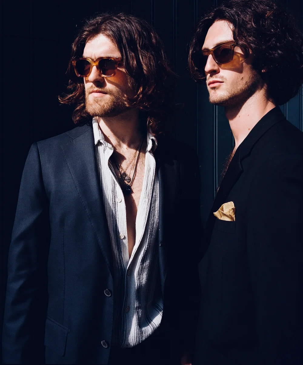 GODFEARING's Brandon Young and Harvey Wells in dark suits and sunglasses